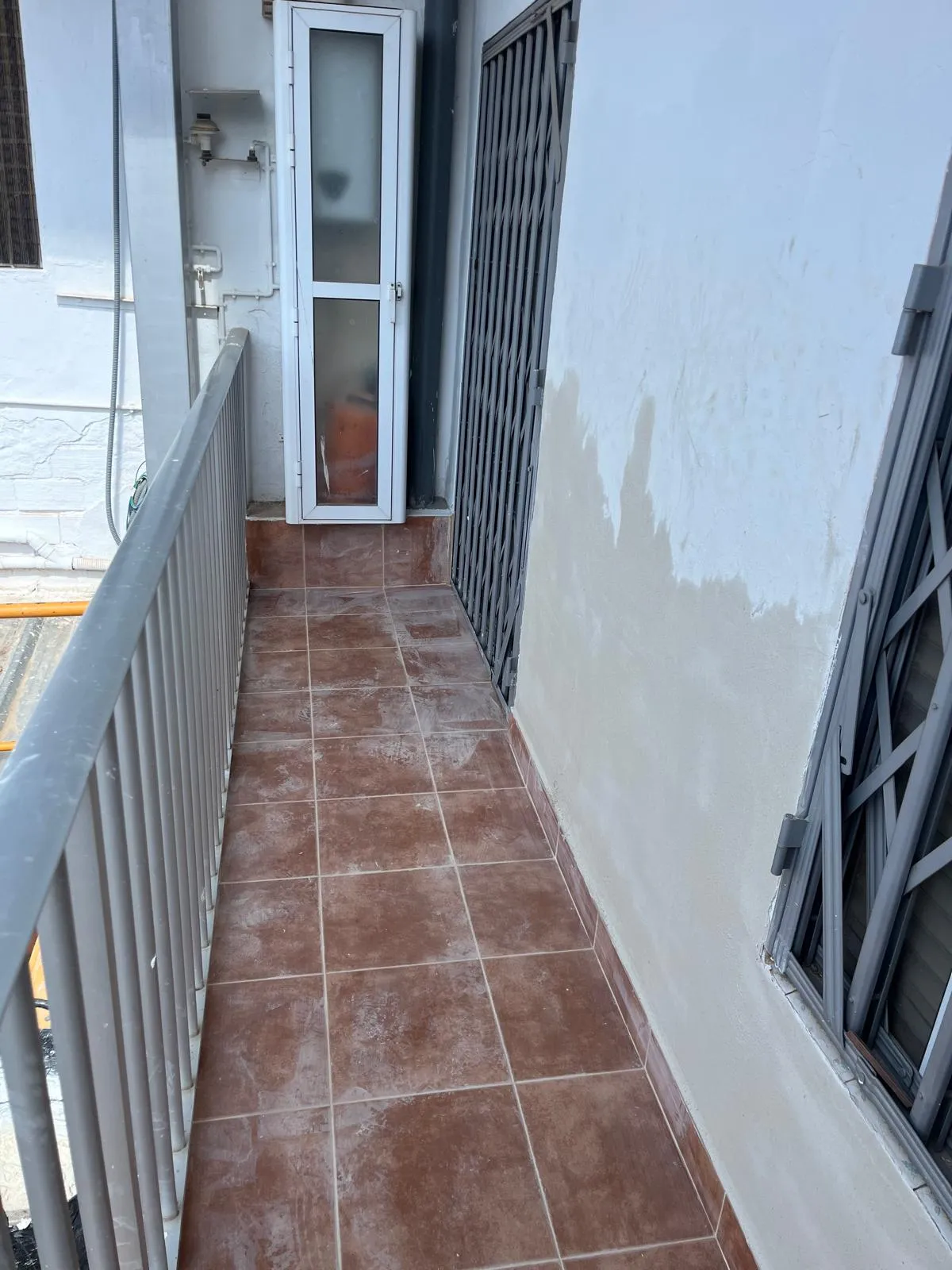 Suelo de baldosa de un balcón junto a la barandilla