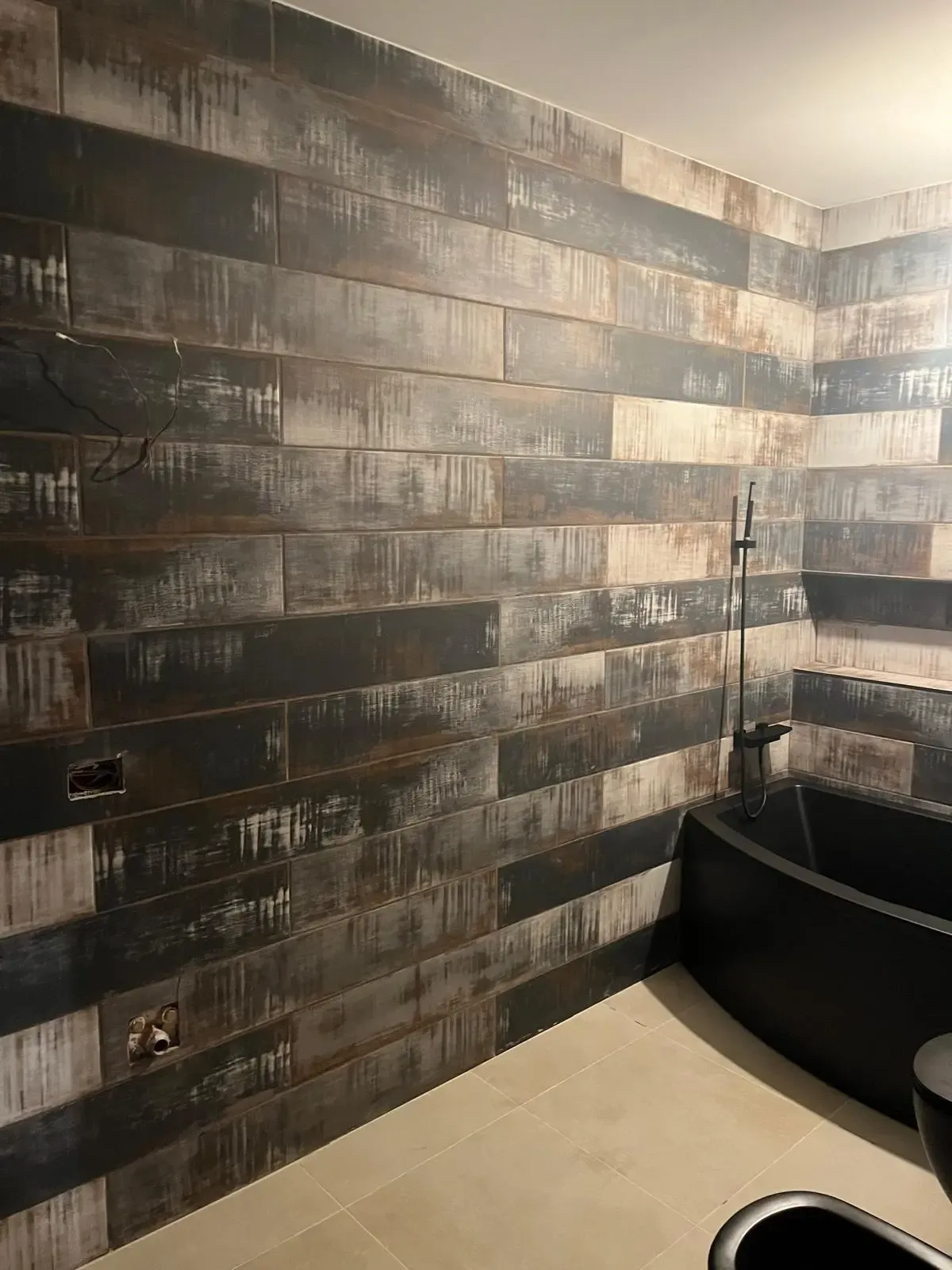 Detalle de la cerámica efecto madera envejecida colocada en horizontal en la esquina del baño