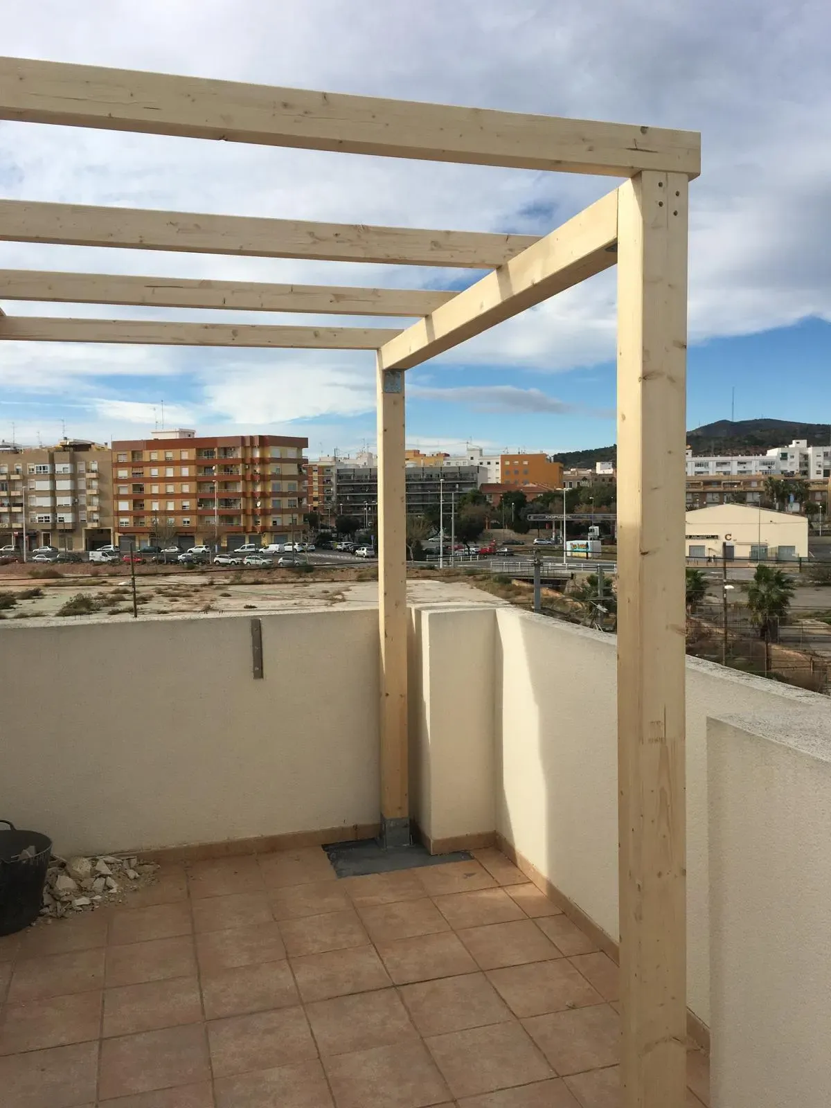 Estructura de madera en una terraza con vistas a la ciudad